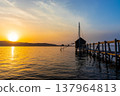 A view of Lake Togo and the setting sun, with a hut for observing the four-pronged net fishing method floating at the end of the pier. 137964813