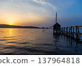 A view of Lake Togo and the setting sun, with a hut for observing the four-pronged net fishing method floating at the end of the pier. 137964818
