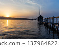 A view of Lake Togo and the setting sun, with a hut for observing the four-pronged net fishing method floating at the end of the pier. 137964822