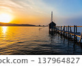 A view of Lake Togo and the setting sun, with a hut for observing the four-pronged net fishing method floating at the end of the pier. 137964827
