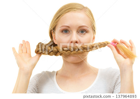 Blonde girl covering her mouth with braid hair 137964893