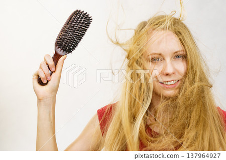 Blonde girl long blowing hair holds natural bristles brush Blonde girl long blowing hair holds natural bristles brush 137964927