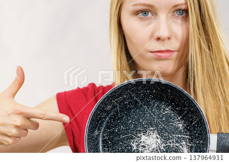 Girl holding scratched frying pan 137964931