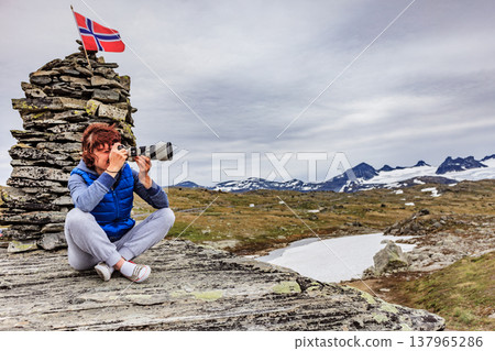 Tourist with camera in Norway mountains Tourist with camera in Norway mountains 137965286