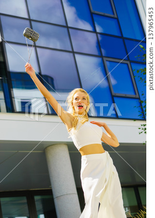 Cheerful fashionable woman in city Cheerful fashionable woman in city 137965453