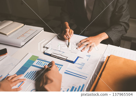 Two business people talk project strategy at office meeting room. Businessman discuss project planning with colleague at modern workplace while having conversation and advice on financial data report. Two business people talk project strategy at office meeting room. Businessman discuss project planning with colleague at modern workplace while having conversation and advice on financial data report. 137965504