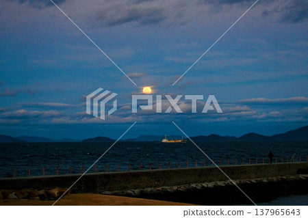 The full moon of March rising from the sea during magic hour. 137965643