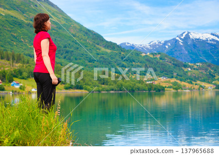 Tourist woman enjoying fjord view in Norway Tourist woman enjoying fjord view in Norway 137965688