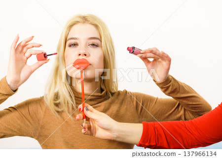 Woman applying lipstick or lip gloss Woman applying lipstick or lip gloss 137966134