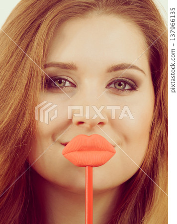 Woman holding big red fake lips Woman holding big red fake lips 137966135
