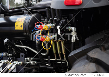 Close-up of hydraulic hoses and connectors on machinery equipment. 137966369