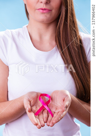Woman with breast cancer awareness ribbon on hands Woman with breast cancer awareness ribbon on hands 137966402