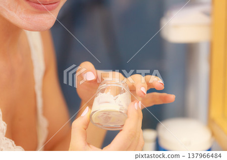 Moisturizing cream in female hands in bathroom Moisturizing cream in female hands in bathroom 137966484