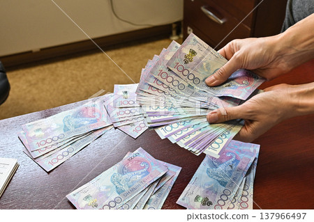 Tenge. Paper Kazakh money and calculator on the table close-up. 137966497