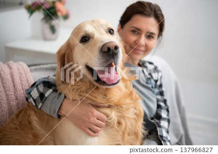 Female Owner At Home With Adorable Golden Retriever Dog 137966827