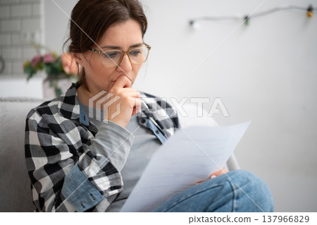 Girl In Glasses Reading Unpleasant Notice With Financial Information 137966829