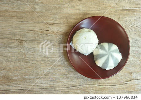 Chinese steamed bun stuffed sweet mashed red bean and salty chop pork on plate Chinese steamed bun stuffed sweet mashed red bean and salty chop pork on plate 137966834