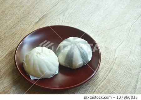 Chinese steamed bun stuffed sweet mashed red bean and salty chop pork on plate 137966835
