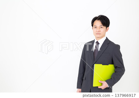 手拿活頁夾的中年商人。 手拿活頁夾的中年商人。 137966917