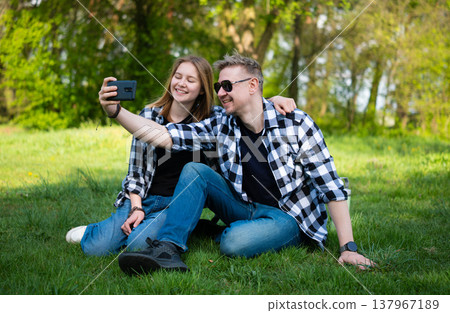 Happy Father And Daughter Taking Selfie With Smartphone On Grass Happy Father And Daughter Taking Selfie With Smartphone On Grass 137967189