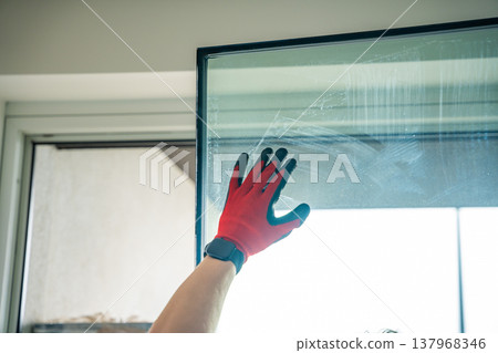 Removed triple glazed window glass unit leaning near frame after replacement in apartment. Broken insulated glass panel removal and window repair process concept. Removed triple glazed window glass unit leaning near frame after replacement in apartment. Broken insulated glass panel removal and window repair process concept. 137968346