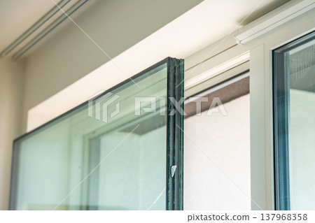 Removed triple glazed window glass unit leaning near frame after replacement in apartment. Broken insulated glass panel removal and window repair process concept. Removed triple glazed window glass unit leaning near frame after replacement in apartment. Broken insulated glass panel removal and window repair process concept. 137968358