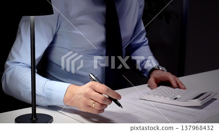 Professional businessman analyzing financial data and statistics, calculating costs, making important budget reports at office desk. Audit and taxes theme in business Professional businessman analyzing financial data and statistics, calculating costs, making important budget reports at office desk. Audit and taxes theme in business 137968432
