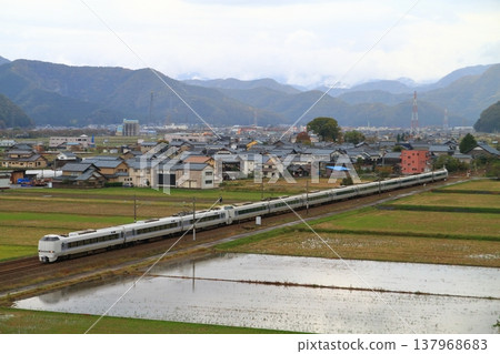 A limited express train on the Hokuriku Main Line runs through a rural landscape. A limited express train on the Hokuriku Main Line runs through a rural landscape. 137968683