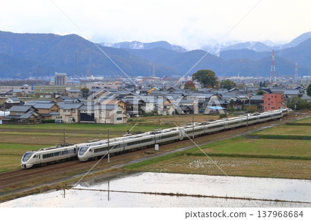 A limited express train on the Hokuriku Main Line runs through a rural landscape. A limited express train on the Hokuriku Main Line runs through a rural landscape. 137968684