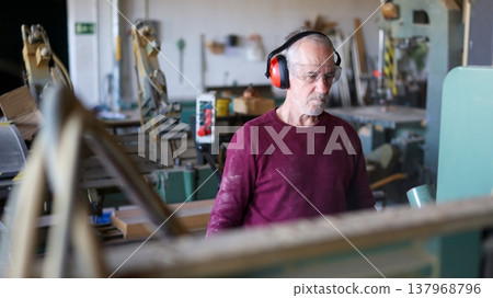 Experienced carpenter working with wood in workshop Experienced carpenter working with wood in workshop 137968796