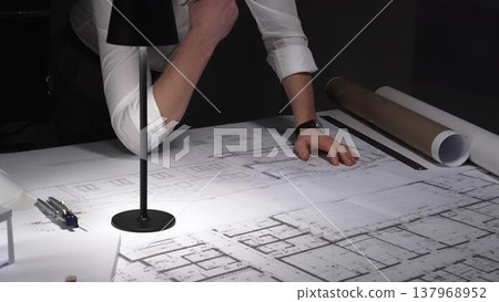 Tired man working overtime on architectural plans, struggling with fatigue, stress, and project deadlines in a dimly lit office. Tired man working overtime on architectural plans, struggling with fatigue, stress, and project deadlines in a dimly lit office. 137968952