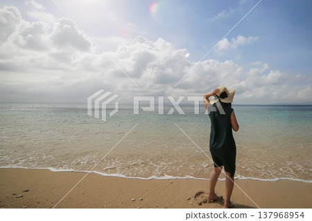一位女子背對著鏡頭，凝視著熱帶海灘。 137968954