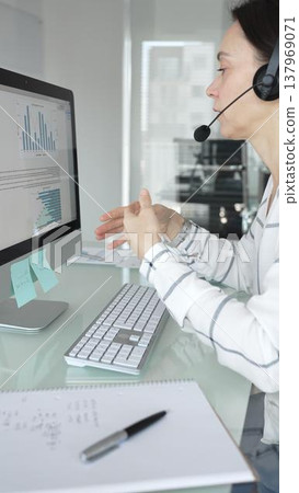 Woman working in call center, providing customer support through headset, communicating in virtual office meeting. Business people concept 137969071