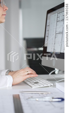 Architect working on building blueprint plans, designing new projects with computer and drawing tools. Business and architecture concept 137969168