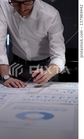 Professional businessman working late nights in office, analyzing financial data and statistics, managing overwork and project deadlines to achieve business success and productivity Professional businessman working late nights in office, analyzing financial data and statistics, managing overwork and project deadlines to achieve business success and productivity 137969442