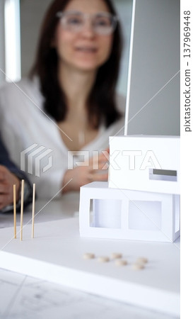 Architects and engineers collaborating on a project, analyzing construction blueprints with drafting tools during client meeting. Business people and architecture concept 137969448