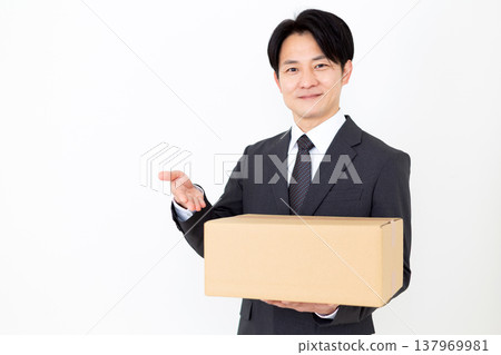 A middle-aged businessman carrying cardboard boxes. A middle-aged businessman carrying cardboard boxes. 137969981