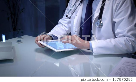 Medical doctor analyzing digital health records on a tablet computer, ensuring patient data management and secure care information in a modern clinic setting Medical doctor analyzing digital health records on a tablet computer, ensuring patient data management and secure care information in a modern clinic setting 137970295