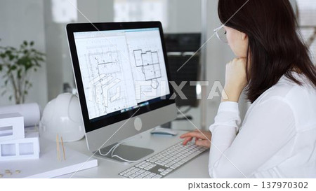 Woman architect analyzing construction blueprint on computer screen in modern design office, planning new building project. Business and architecture concept Woman architect analyzing construction blueprint on computer screen in modern design office, planning new building project. Business and architecture concept 137970302