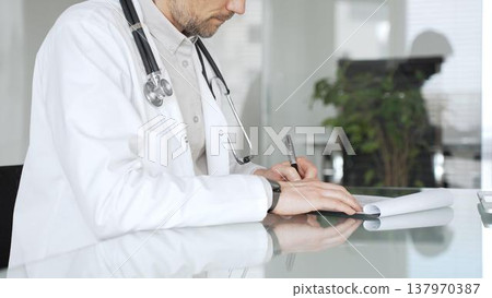 Doctor man writing prescription, consulting patient, and working at clinic office, providing healthcare and medicine. Medicine, health care and science concept 137970387