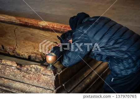 Christian pilgrims' hands on the Stone of Anointing, Holy Sepulchre. 137970765