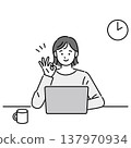 一位微笑的女士一邊在電腦前工作，一邊比出「OK」手勢。 137970934