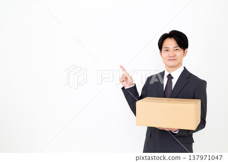 A middle-aged businessman carrying cardboard boxes. 137971047
