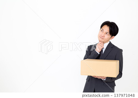 一位中年商人正在費力地搬運紙箱。 137971048