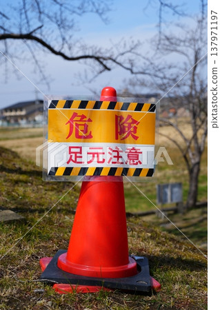 A red cone and a sign that reads "Watch your step." 137971197
