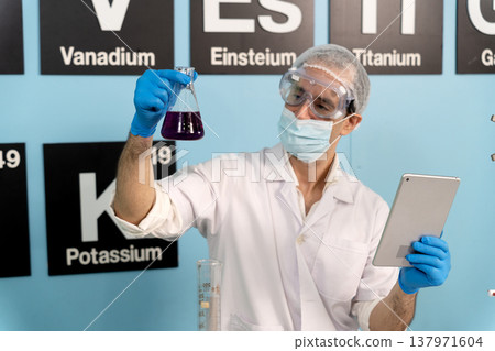 Chemist scientist is mixing chemicals for scientific research using laptop 137971604