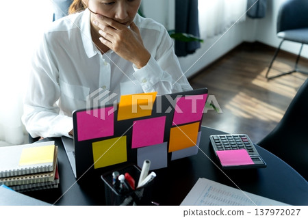 businesswoman looking at laptop with many color notes businesswoman looking at laptop with many color notes 137972027