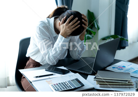 Businesswoman holding her head showing stressful headache Businesswoman holding her head showing stressful headache 137972029