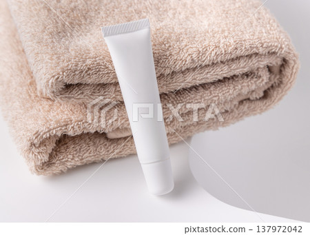 White cosmetic eye cream tube mockup near beige bath towel. Skincare product packaging White cosmetic eye cream tube mockup near beige bath towel. Skincare product packaging 137972042