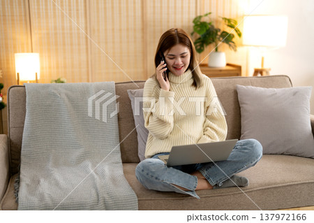young asian woman sitting using smartphone communicating with colleagues and clients via online system 137972166